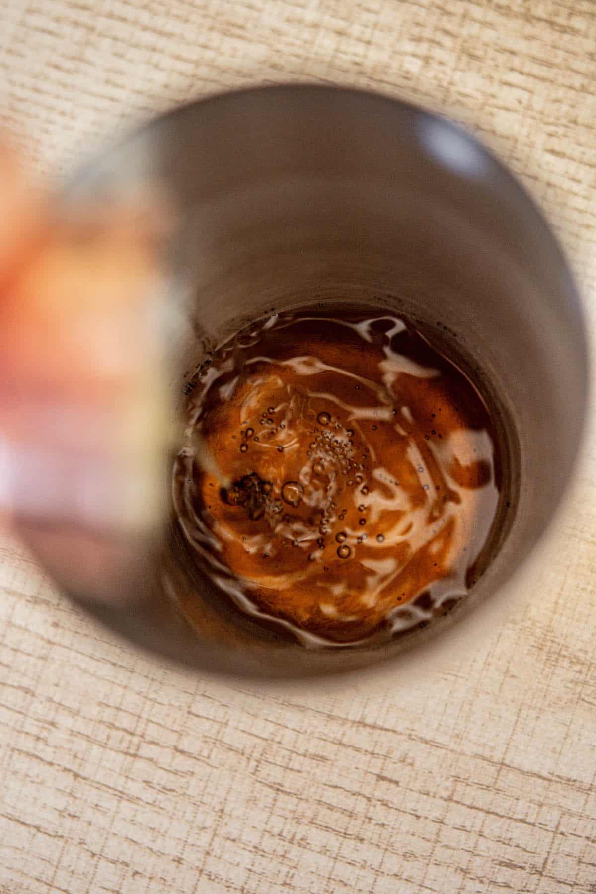 rum being poured into cocktail shaker.