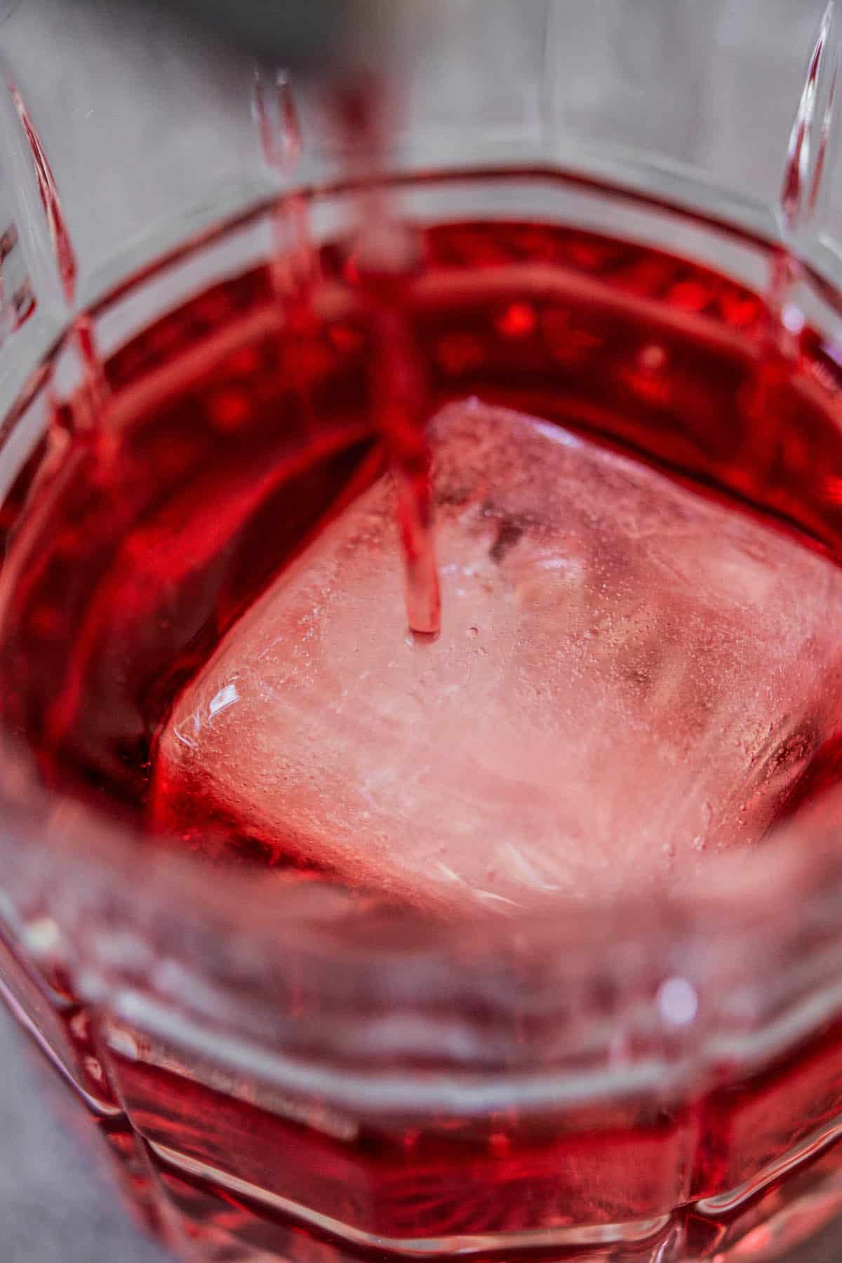 red liquid poured over ice cube.