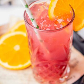 Madras Cocktail with orange slices on the rim and a straw.